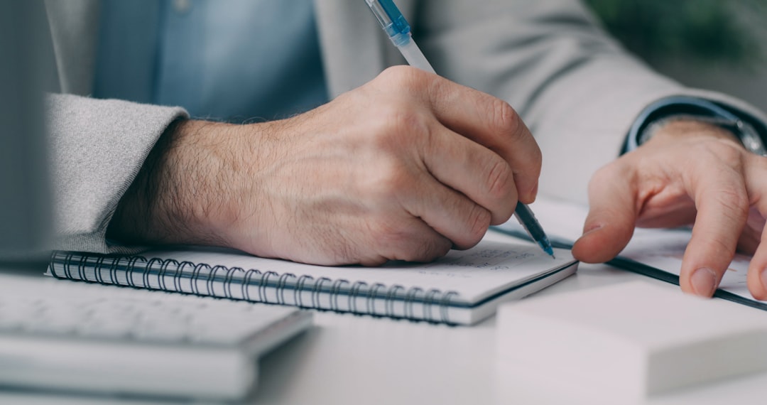 a-man-in-a-suit-writing-on-a-notebook-xauiz6wazmk